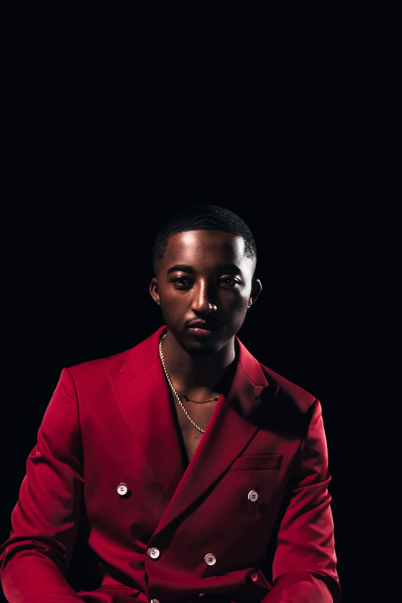 Portrait of Nijel B. Murray in a red suit.