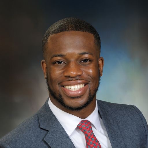 Headshot of Dr. Randy Obi in a gray suit and red tie